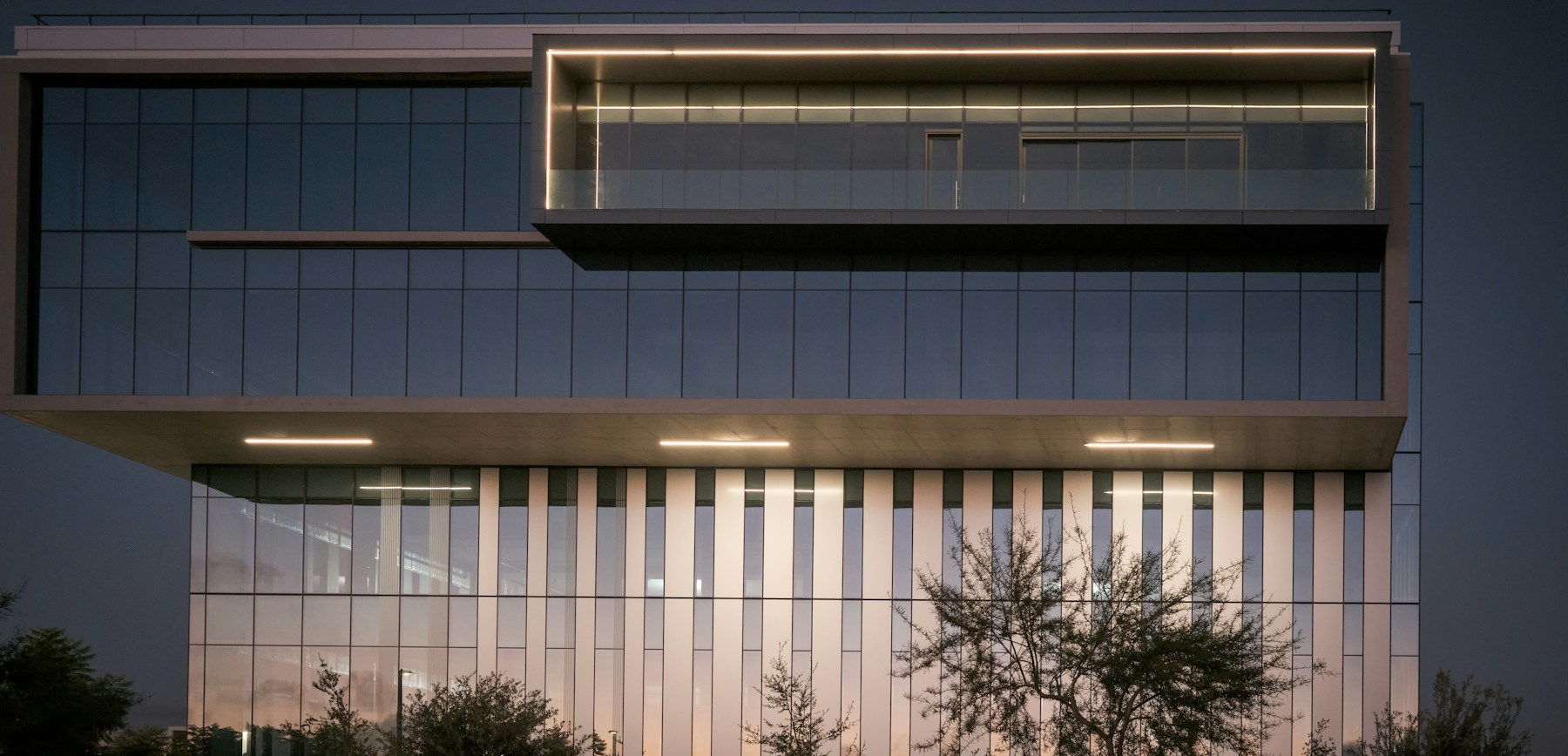 Contemporary glass commercial building at dusk